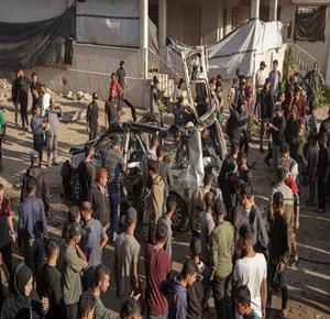 مواطنون يتفقدون المركبة التي استهدفت بقصف إسرائيلي في منطقة العباس غرب مدينة غزة